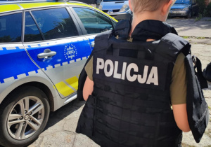 W kamizelce kuloodpornej.