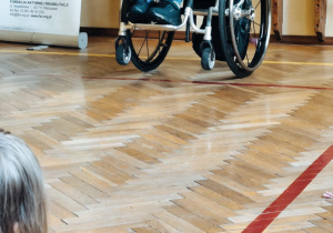 Dzieci z pracownikiem fundacji FAR sprawdzają perspektywę osób poruszających się na wózku