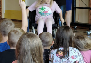 Dzieci z pracownikiem fundacji FAR sprawdzają perspektywę osób poruszających się na wózku