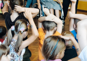 Dzieci z pracownikiem fundacji FAR sprawdzają perspektywę osób poruszających się na wózku